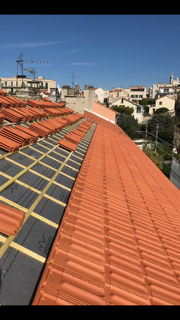 Pose de tuiles plates marseillaises sur la toiture d'un immeuble près de la Corniche, Marseille (13007)