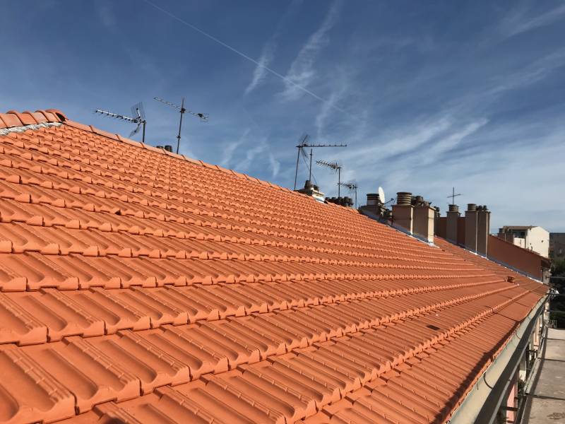 Rénovation de la couverture en tuiles plates marseillaises sur le toit d'une résidence sur la Corniche, à Marseille
